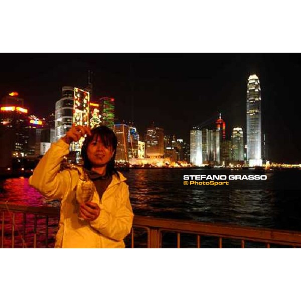 Marya Tsang just after fishing a small sea plum in front of Hong Kong skyline Hong Kong 11-12-03 ph. Stefano Grasso